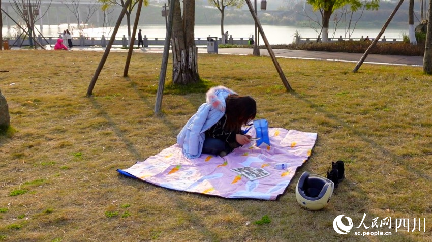 市民在花萼濕地公園草坪曬太陽。鐘欣航攝