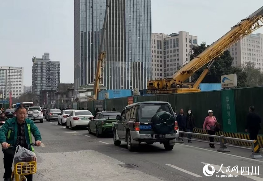 道路一側，地鐵建設穩步推進，一邊，車流人流有序通行，建設單位加緊施工邊雨進一步釋放通行道路。人民網記者 郭瑩攝