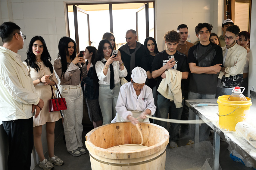 外國游客現場觀看中江手工掛面制作過程.JPG
