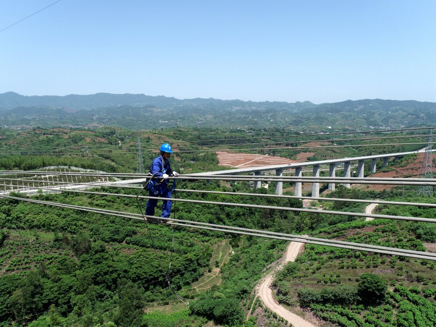 5月12日，在四川省宜賓市高縣，國網四川超高壓公司運檢人員對錦屏—蘇南特高壓工程跨越渝昆高鐵遷改區段進行走線驗收。田德均攝