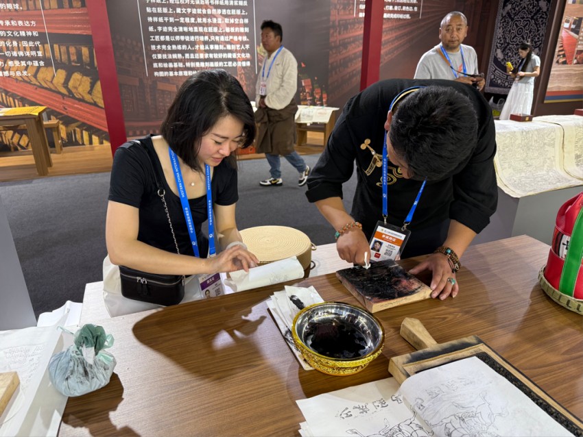 西博會非遺展示互動體驗區正在體驗的觀眾。甘孜州委宣傳部供圖