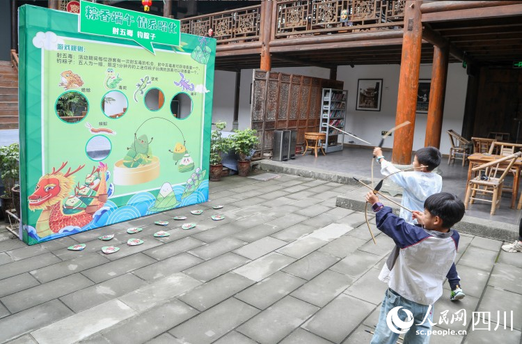 小游客參與“射五毒”活動。李建生攝