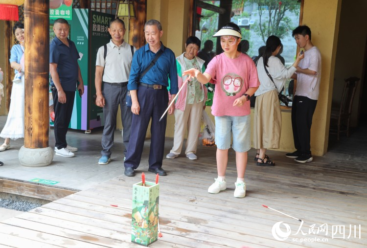 游客參與投壺活動。李建生攝