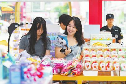7月14日，游客在官方特許商品零售店紅星路店挑選世運會周邊商品。