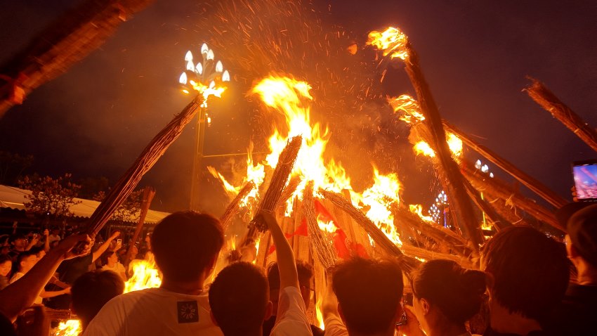 民眾利用火堆點燃各自的小火把。何婧雯攝