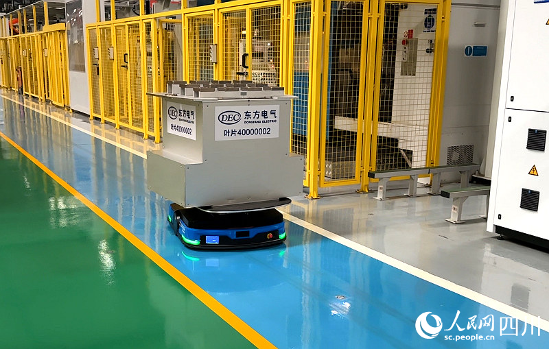 AGV智能無人運輸小車馱著超過自身體積數倍的待加工材料穿梭在車間內。張越攝