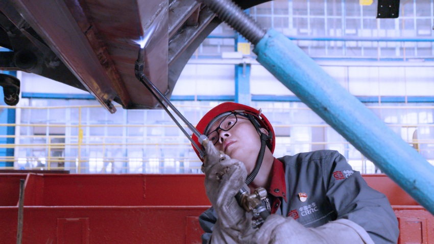 甘俊林正在為出口澳大利亞的糧食漏斗車進行烤火矯正工作。受訪者供圖