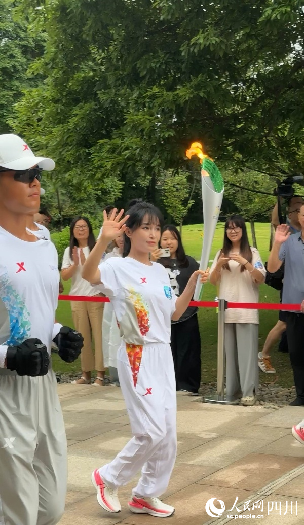 李子柒一邊傳遞一邊向場邊揮手。成都世運會執委會供圖