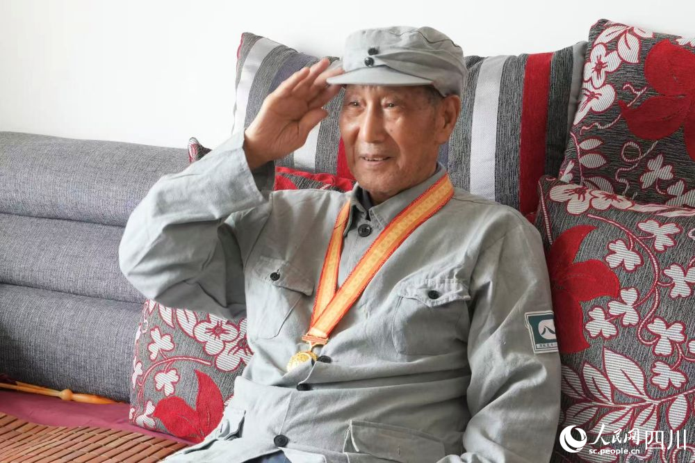 孟憲華向閱兵直播畫面敬禮。人民網記者 李平攝