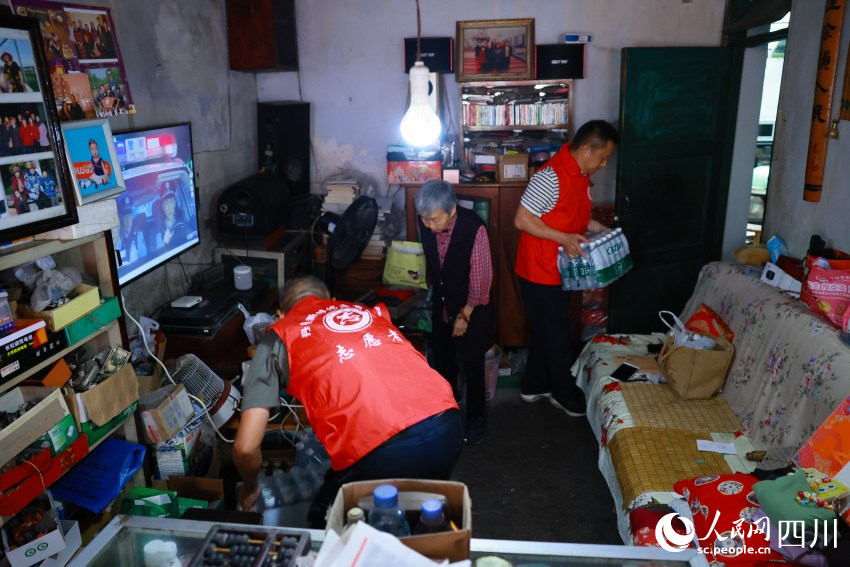 “齊樂先鋒隊”志愿者幫駱舒程清理雜物。王雅竹攝