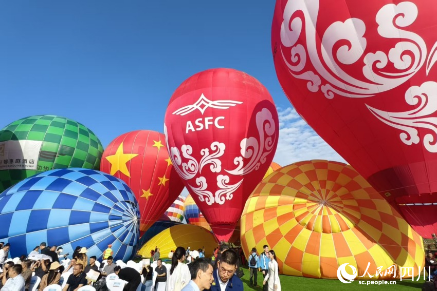 參賽選手正在為熱氣球充氣與點火。人民網 趙祖樂攝