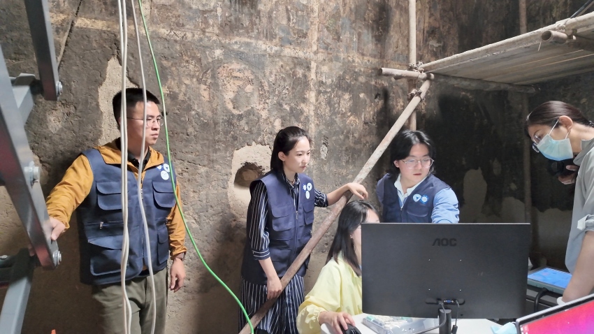 2015年7月在新疆克孜爾161窟，張曉秋艷和團隊成員對壁畫進行檢測分析。受訪者供圖