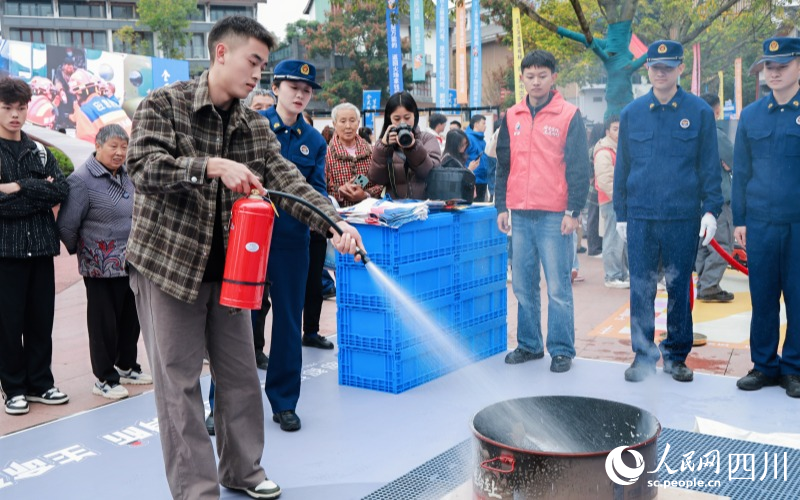 市民群眾實操滅火器滅火。實習生 鄭宇丹攝