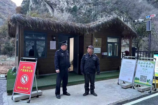 溫軍文（左）在和秦嶺聯防的民間工作人員交談。李凱攝